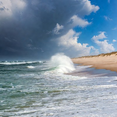 Waves crash on sandy beach shoreline