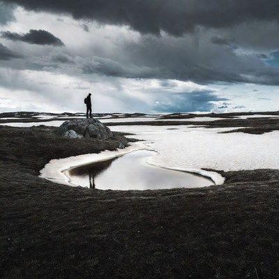 Man standing on rock in snowy landscape