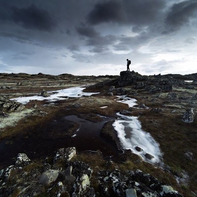 Person standing on rock in remote landscape