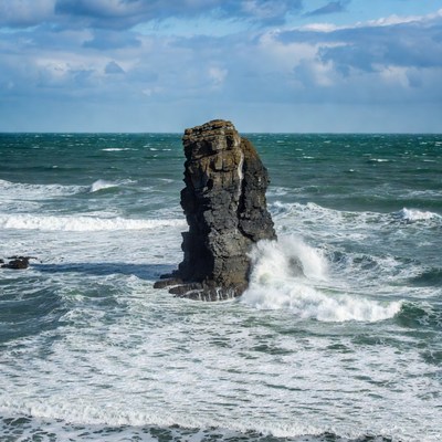 Rock standing in ocean waves
