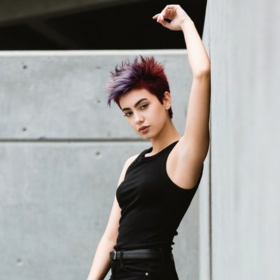 Young person poses against wall