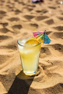 Drink with umbrella on beach sand