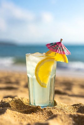 Lemon drink on beach sand