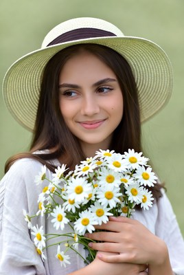 Young woman with daisies in field