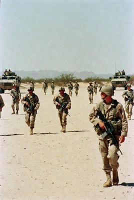 Soldiers march in desert landscape