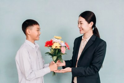 Boy giving flowers to woman