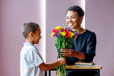 Child gives flowers to adult