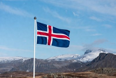 Waving flag against mountain backdrop in iceland