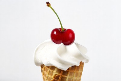Tasty ice cream cone with cherry