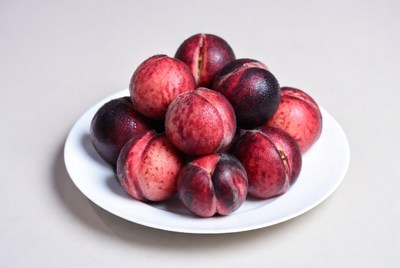 Red and black fruit on white plate