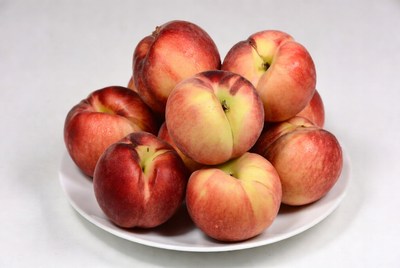 Fresh peaches on a white plate