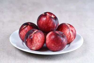 Fresh peaches on a white plate