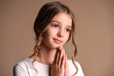 Girl with hands together smiling