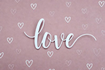 Word love on a pink background with hearts
