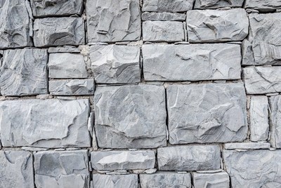 Gray stone wall with rough texture
