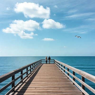 Couple standing on wooden pier over ocean