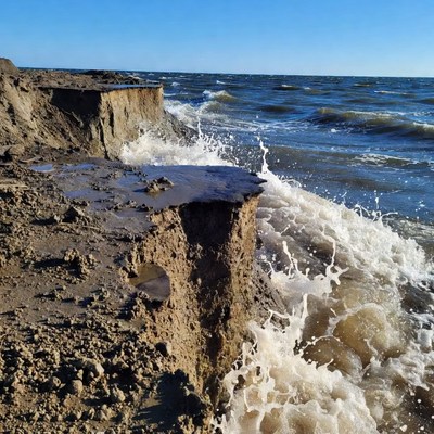 Waves crash against eroding shoreline