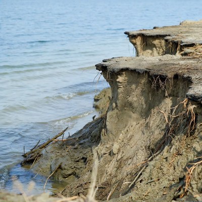 Erosion along riverbank with exposed soil