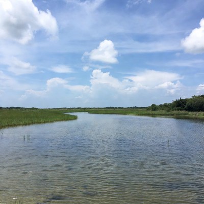 River and grassland under blue sky