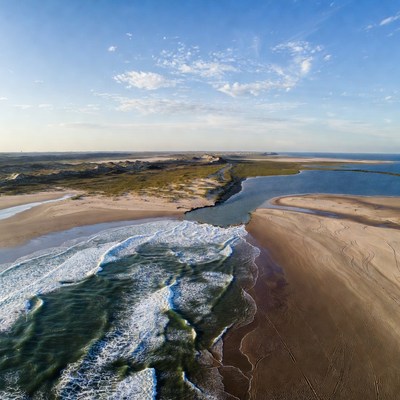 Waves meet river at the shoreline