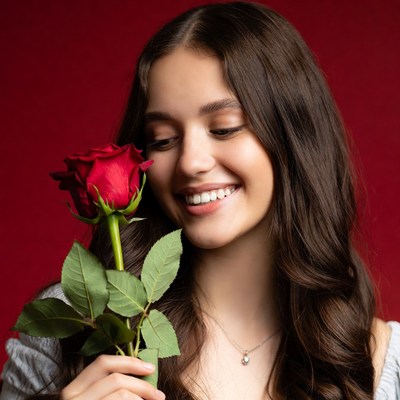 Young woman holds red rose