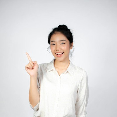 Young woman points with smile