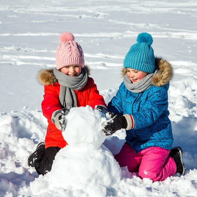 Kids building a snowman in winter