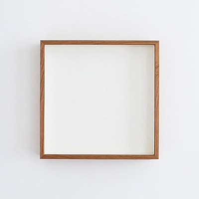 Empty wooden frame on white wall