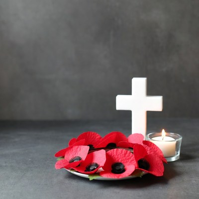 Poppy flowers and white cross on table
