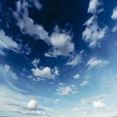 Clouds in clear blue sky over open space