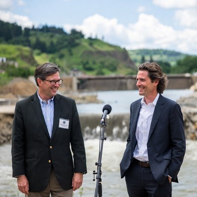 Men giving speech by riverbank at community event