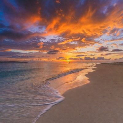 Sunset over sandy beach and water