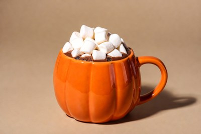 Hot drink with marshmallows in orange cup