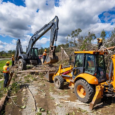 Workers clear debris with machinery