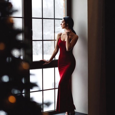 Woman in red dress by window