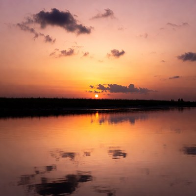 Sunset over still water reflection