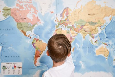 Child exploring world map at home