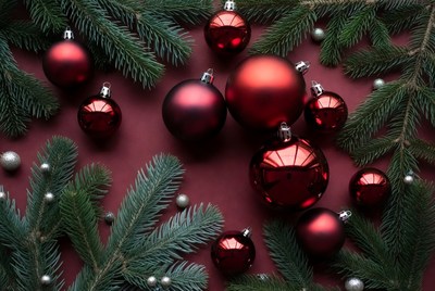 Red ornaments and pine branches on table