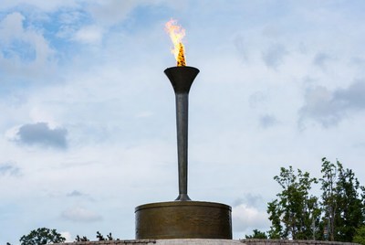 Torch monument with flame in park