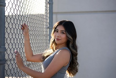 Young woman poses by fence