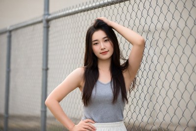 Woman posing by a fence