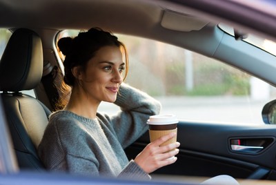 Woman enjoys coffee in car