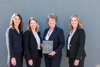 Women in suits hold award