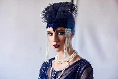 Model posing in blue costume with feathers