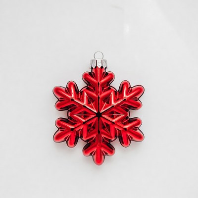 Red snowflake ornament hanging on white background