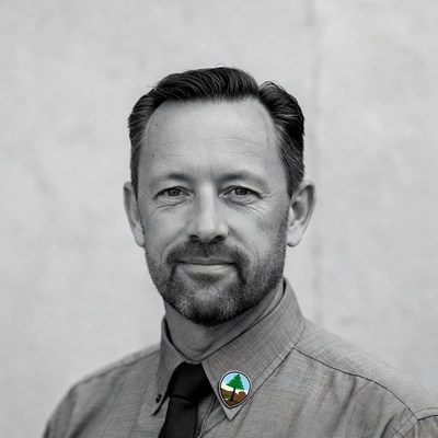 Man in gray shirt with badge