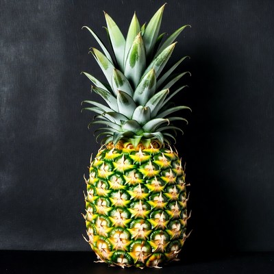 Whole pineapple against black backdrop