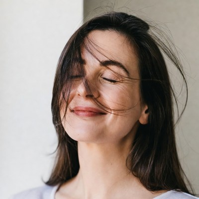 Woman enjoys gentle breeze indoors