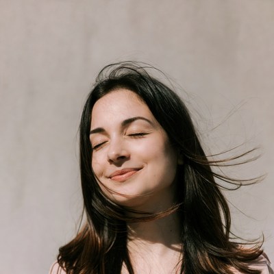 Woman smiles in outdoor sunlight