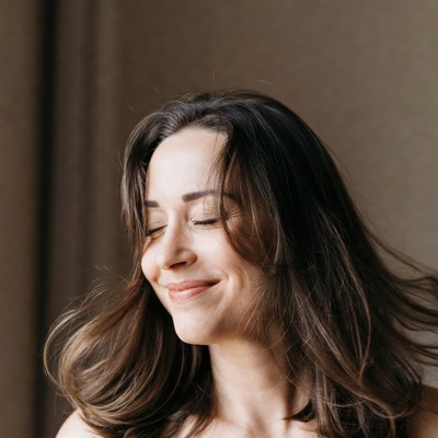 Woman smiles with eyes closed